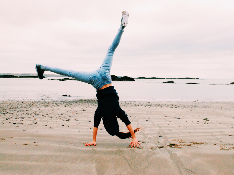 Lady on a beach doing a cartwheel for Coaching Menopause case study